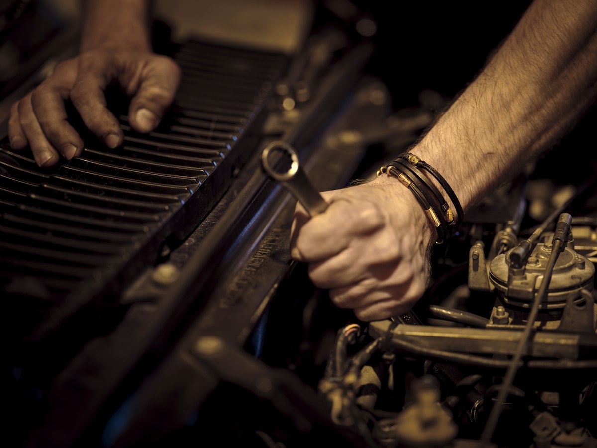 Illustrative close-up of hands carrying out engine repairs